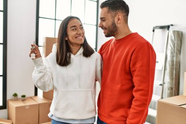 Genç İspanyol çift gülümsüyor mutlu bir şekilde yeni evin anahtarını tutuyor..