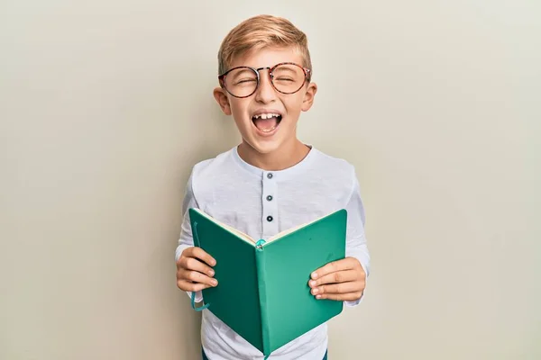 Pequeno Garoto Caucasiano Lendo Livro Usando Óculos Sorrindo Rindo Forte — Fotografia de Stock
