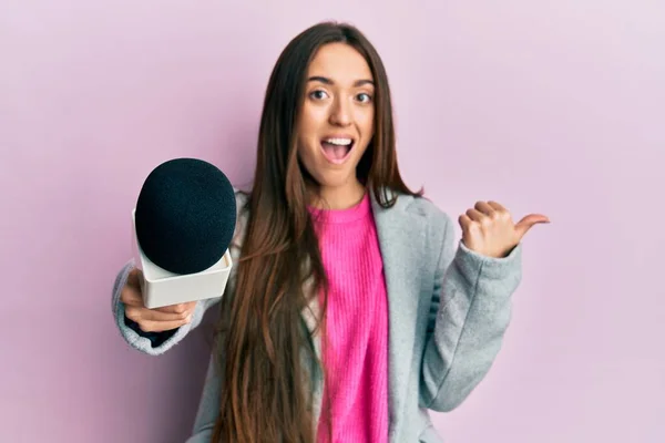 Menina Hispânica Jovem Segurando Microfone Repórter Apontando Polegar Até Lado — Fotografia de Stock