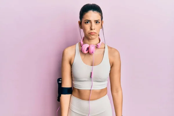 Mujer Hispana Joven Que Usa Ropa Gimnasia Usa Auriculares Deprimidos —  Fotos de Stock