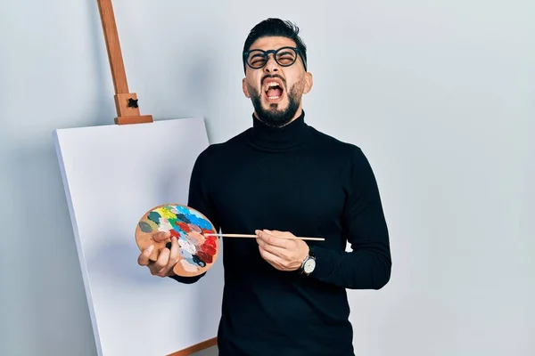 Hombre Guapo Con Barba Sosteniendo Paleta Cepillo Cerca Caballete Pie —  Fotos de Stock