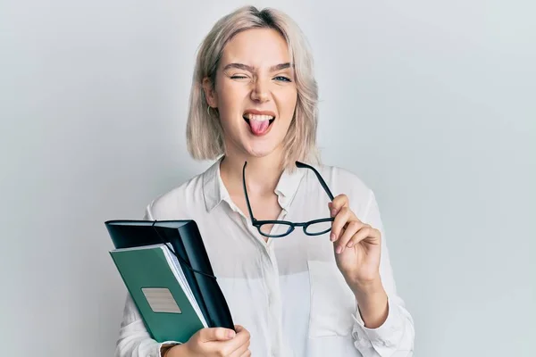 Młoda Blondynka Czyta Książkę Trzyma Okulary Wystający Język Szczęśliwy Zabawnym — Zdjęcie stockowe
