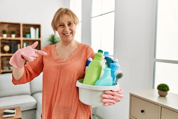 Mulher Loira Meia Idade Segurando Produtos Limpeza Limpeza Casa Apontando — Fotografia de Stock