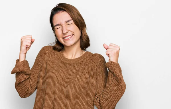 穿着休闲装的年轻的高加索女孩非常高兴而兴奋地举起双臂做着获胜的手势 微笑着 尖叫着要成功 庆祝概念 — 图库照片