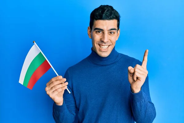 Hombre Hispano Guapo Sosteniendo Bandera Bulgara Sonriendo Feliz Señalando Con —  Fotos de Stock