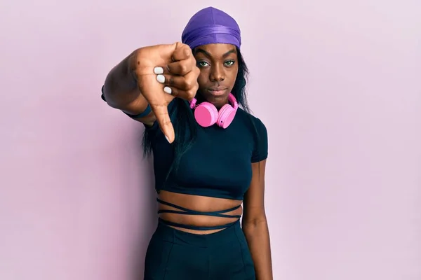 Mladá Afro Americká Žena Tělocvičně Používající Sluchátka Vypadající Nešťastně Rozzlobeně — Stock fotografie