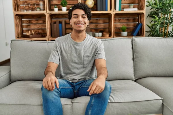 Joven Hombre Hispano Usando Ropa Casual Sentado Sofá Casa Mirando —  Fotos de Stock