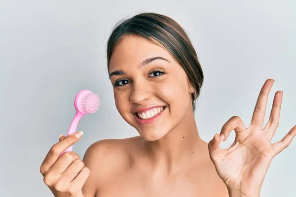 Jovem Morena Usando Escova Esfoliante Facial Fazendo Sinal Com Dedos — Fotografia de Stock