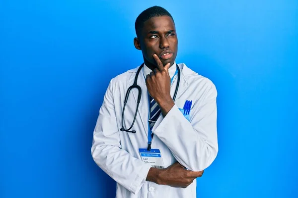 Joven Hombre Afroamericano Vistiendo Uniforme Médico Con Mano Barbilla Pensando — Foto de Stock
