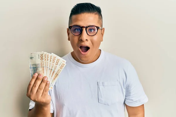 Joven Latino Sosteniendo Billetes 100 Coronas Danesas Asustado Sorprendido Con —  Fotos de Stock