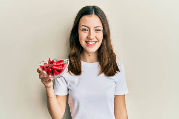 Jovem Morena Segurando Pimentas Vermelhas Olhando Positivo Feliz Sorrindo Com — Fotografia de Stock