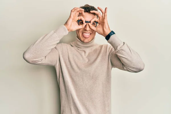 스페인 청년은 터틀넥 스웨터 쌍안경으로 내밀고 손가락을 응시하는 것처럼 일사불란 — 스톡 사진