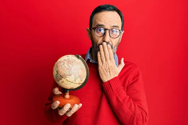 Homem Hispânico Meia Idade Segurando Bola Mundo Vintage Cobrindo Boca — Fotografia de Stock