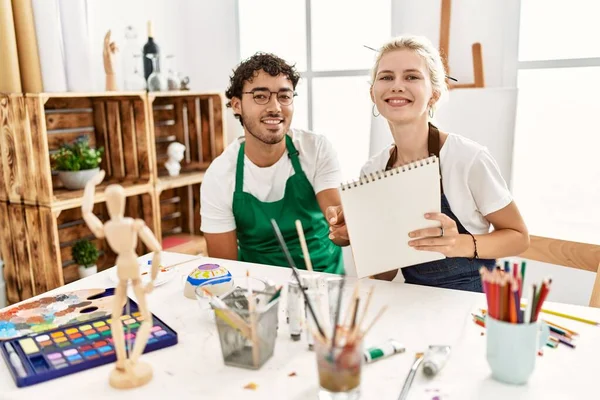 年轻的艺术家夫妇在艺术工作室里开心地微笑着绘画 — 图库照片