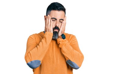 Kış süveteri giyen İspanyol sakallı adam. Yüzü, depresyonu ve üzüntüyü örten yorgun eller. Sorun yüzünden üzgün ve tedirgin. 