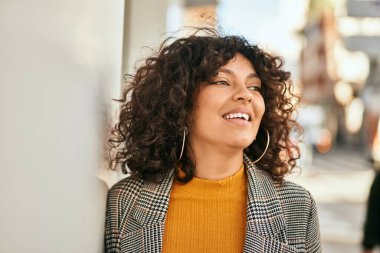 Genç İspanyol iş kadını şehirde mutlu mesut ayakta duruyor..