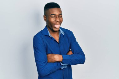 Kollarını kavuşturmuş genç Afro-Amerikalı adam komik bir ifadeyle dilini dışarı çıkartıyor.. 