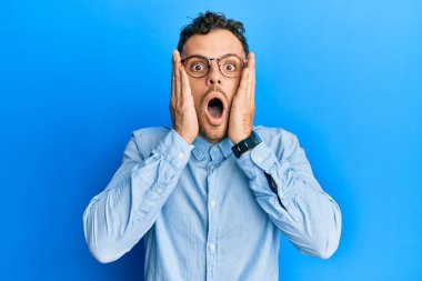 Gündelik kıyafetler ve gözlük takan genç İspanyol adam korkmuş ve şok olmuş, şaşırmış ve şaşırmış bir yüz ifadesi var. 