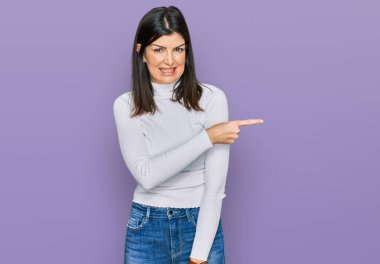 Güzel esmer kadın, gündelik giysiler içinde endişeli ve gergin bir şekilde işaret ediyor. 