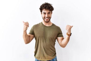 Hispanik adam izole edilmiş beyaz arka plan başarı işaretinin üzerinde duruyor. Elleriyle olumlu jest yapıyor, gülümsüyor ve mutlu. Neşeli ifade ve kazanan jest. 