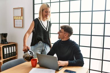 Ofiste çalışırken ve kahve içerken gülümseyen iki iş adamı..