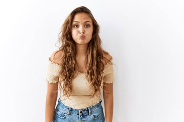 Arka planda komik suratlı yanakları şişirirken yalnız başına duran güzel İspanyol kadın. Havayla şişmiş ağız, çılgın bir ifade.. 