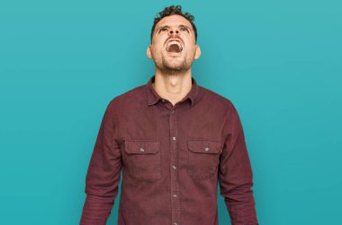 Öfkeli ve kızgın bağıran öfkeli ve öfkeli, öfkeyle bağıran Latin asıllı genç bir adam. öfke ve agresif konsept. 