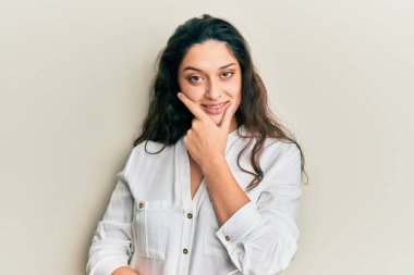 Güzel bir ortadoğulu kadın, gündelik kıyafetler giyip kameraya bakarken kollarını kavuşturup gülümseyerek ve çenesini kaldırarak gülümsüyor. Olumlu düşünmek. 