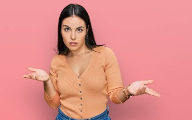 Gündelik kıyafetler giyen genç İspanyol kadın, habersiz ve kolları açık, hiçbir fikri yok.. 