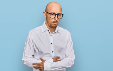 Sakallı, iş gömleği giyen, eli göbeğinde gözlük takan kel bir adam. Çünkü hazımsızlık, acı verici bir hastalık ve kendini iyi hissetmiyor. Ağrı kavramı. 