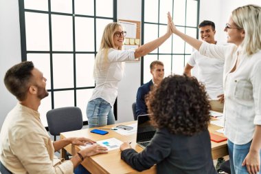 Ofiste buluşurken gülümseyen iki işçi beşlik çakıyor..