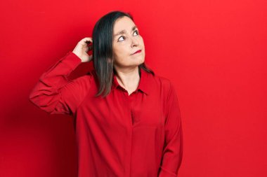 Gündelik kıyafetler giyen orta yaşlı İspanyol kadın soru sorup kafasını karıştırıyor. Şüpheyle kararsız, kafa kafaya düşünerek. Düşünceli kavram. 