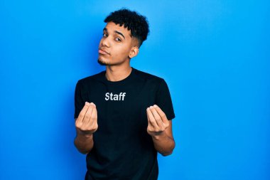 Genç Afro-Amerikan adam personel t-shirt 'ü giyiyor. Elleriyle jest yapıyor. Maaş istiyor, milyoner iş istiyor. 