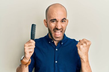 Genç İspanyol adam tarağını tutuyor saçları dökülüyor gururla bağırıyor, zaferi kutluyor ve kollarını kaldırıp başarıyı kutluyor. 