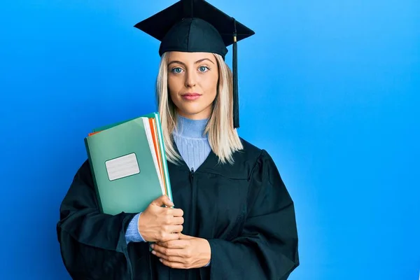 Piękna Blondynka Nosi Czapkę Dyplomową Szlafrok Ceremonii Trzymając Książki Myśląc — Zdjęcie stockowe