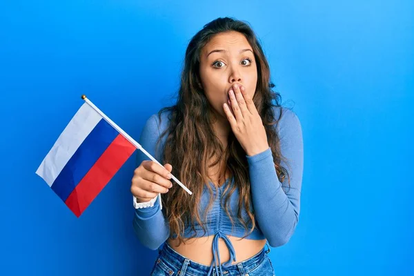 Menina Hispânica Jovem Segurando Bandeira Rússia Cobrindo Boca Com Mão — Fotografia de Stock