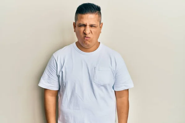 Jovem Latino Vestindo Casual Shirt Branca Cético Nervoso Franzindo Testa — Fotografia de Stock