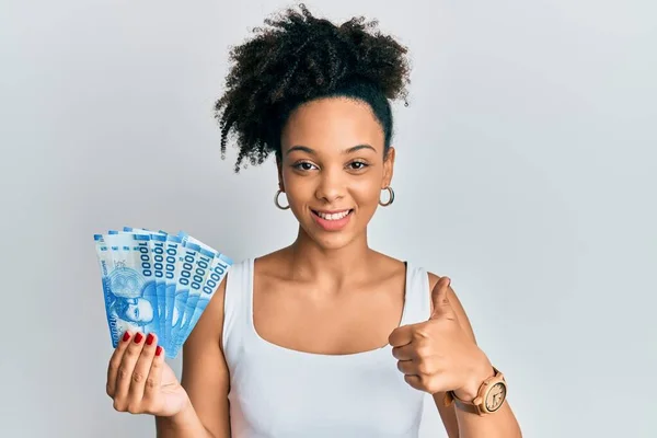 Chica Afroamericana Joven Sosteniendo 10000 Pesos Chilenos Sonriendo Feliz Positivo — Foto de Stock