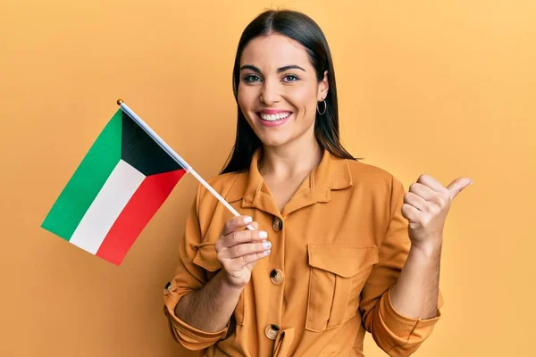 Jovem Morena Segurando Bandeira Kuwait Apontando Polegar Para Lado Sorrindo — Fotografia de Stock