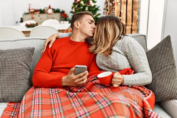 年轻夫妇使用智能手机和喝咖啡 坐在家里的沙发上 — 图库照片