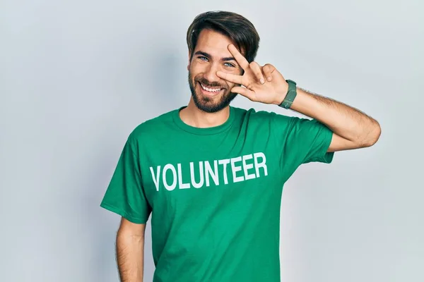 Jovem Hispânico Vestindo Camiseta Voluntária Fazendo Símbolo Paz Com Dedos — Fotografia de Stock