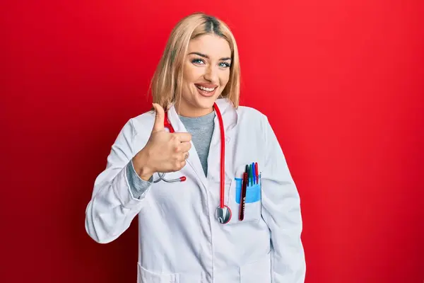 Young Caucasian Woman Wearing Doctor Uniform Stethoscope Doing Happy Thumbs — Stock Photo, Image