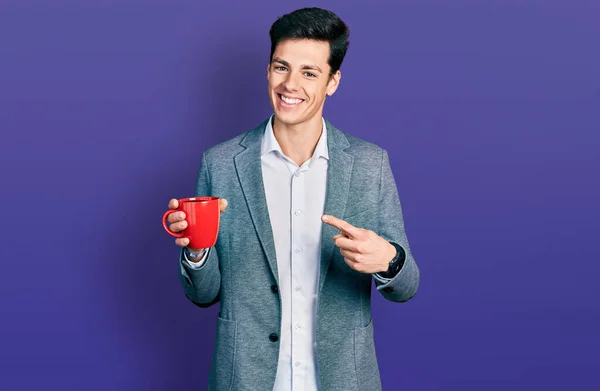 若いヒスパニック系ビジネスマンを身に着けていますビジネススタイルの飲酒カップのコーヒー笑顔幸せなポインティングで手と指 — ストック写真