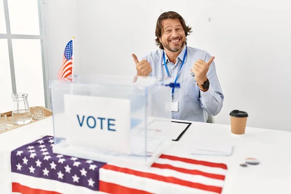 Przystojny Mężczyzna Średnim Wieku Siedzący Przy Głosowaniu Pozytywnym Gestem Uśmiechnięty — Zdjęcie stockowe
