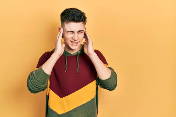 耳の拡張を持つ若い白人の少年は 大きな音楽のノイズのためのいらいらした表情で指で耳を覆うカジュアルなスウェットシャツを着ています 聴覚障害の概念 — ストック写真