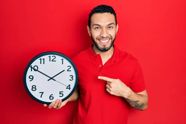 Homme Hispanique Avec Barbe Tenant Grande Horloge Souriant Heureux Pointant — Photo