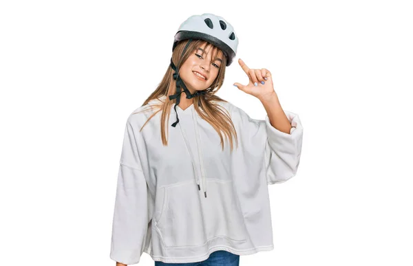 十几岁的女孩头戴自行车头盔 面带微笑 自信地做手势 手拿着小尺寸的标志 手拿着手指 手拿着相机 计量概念 — 图库照片