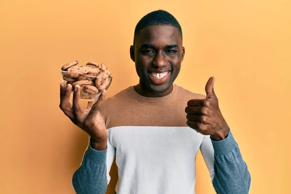 Joven Afroamericano Hombre Sosteniendo Tazón Con Galletas Chips Chocolate Sonriendo — Foto de Stock