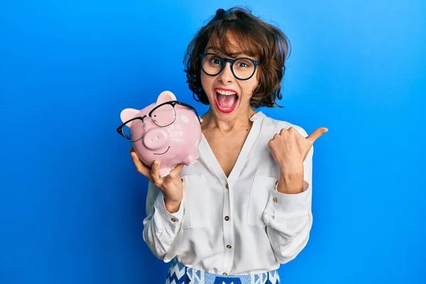 Jong Brunette Vrouw Holding Piggy Bank Met Bril Wijzen Duim — Stockfoto