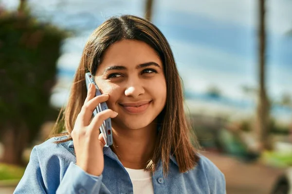 若いですラテン語の女の子笑顔幸せな話上のスマートフォンで街 — ストック写真